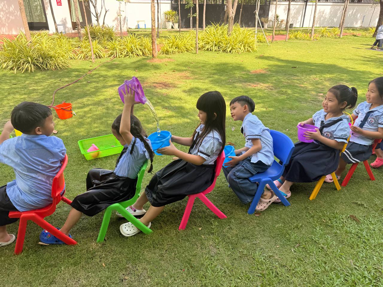 (English Below) ប្អូនៗកុមារថ្នាក់មត្តេយ្យសិក្សារបស់យើង បានចូលរួមនៅក្នុងសកម្មភាពប្រណាំងប្រជែងជញ្ជូនទឹកពីធុងមួយទៅធុងមួយ និងជញ្ជូនកែវទឹកនីមួយៗទៅកាន់គោលដៅ។ ប្អូនបានសហការជាមួយគ្នា ដោយផ្លាស់ប្តូរវេន គោរពតាមការណែនាំ ព្រមទាំងលើកទឹកចិត្តគ្នាទៅវិញទៅមក។នេះគឺជាវិធីសាស្រ្តដ៏ល្អ ព្រមទាំងសប្បាយរីករាយក្នុងការអនុវត្តនូវបំណិនសហការជាក្រុម ក៏ដូចជាពង្រឹងចលនារាងកាយឱ្យមានតុល្យភាពស្របពេលជាមួយគ្នានឹងការកម្សាន្តនៅខាងក្រៅថ្នាក់៕ Our young learners took part in water relay challenges, passing water from bucket to bucket and carefully transporting cups [&hellip;]